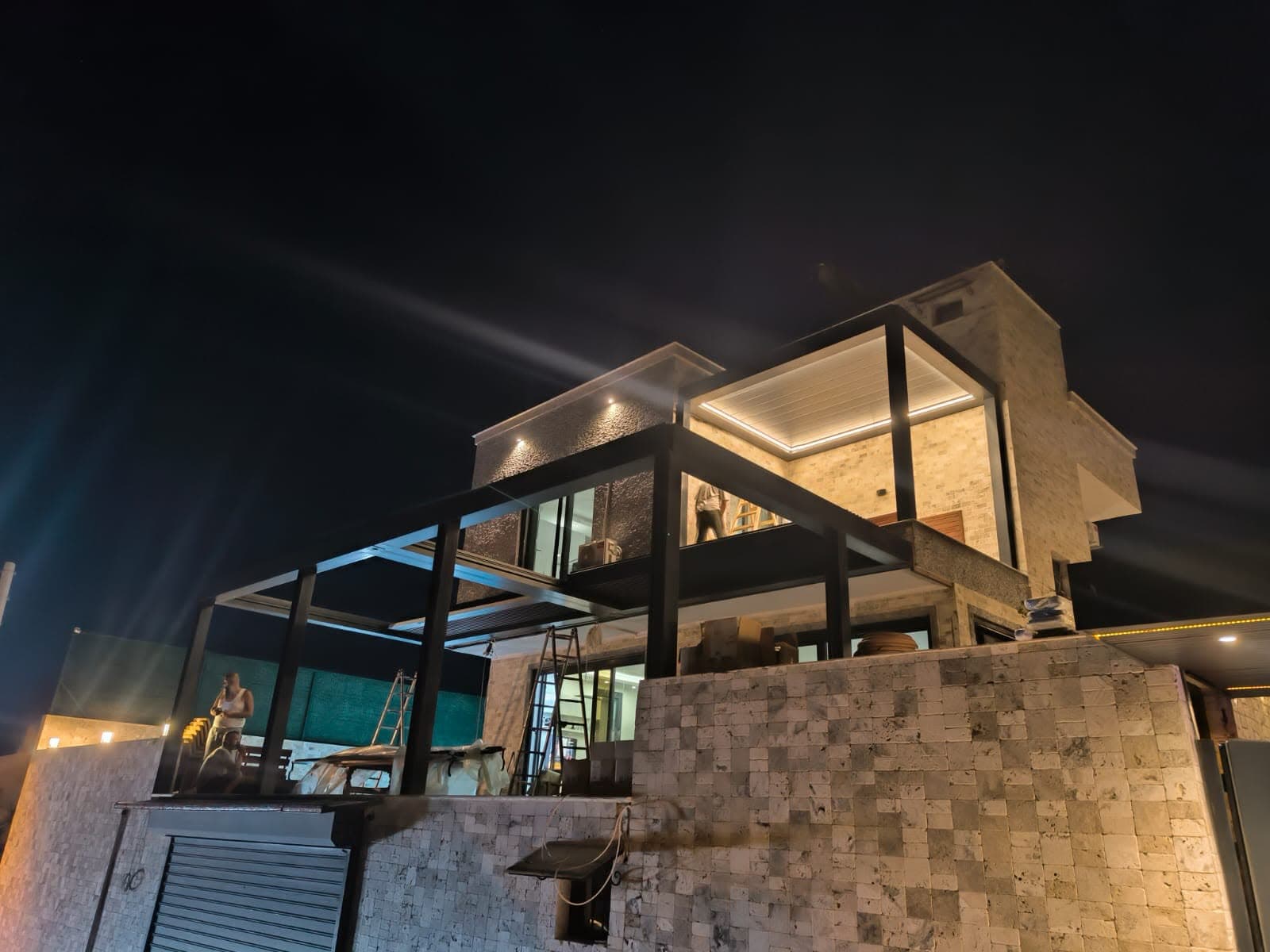 Gece aydınlatmasıyla villa terasında bioklimatik pergola